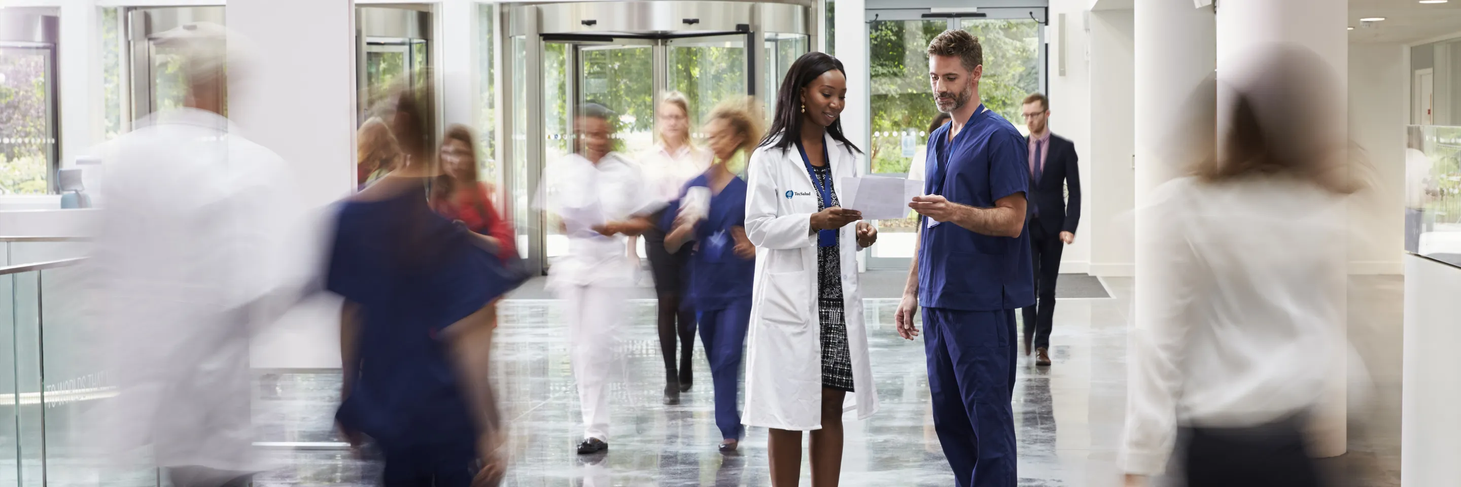 Médicos TecSalud conversando en pasillo hospitalario