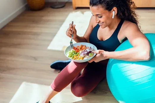 Mujer comiendo comida saludable despues de hacer yoga